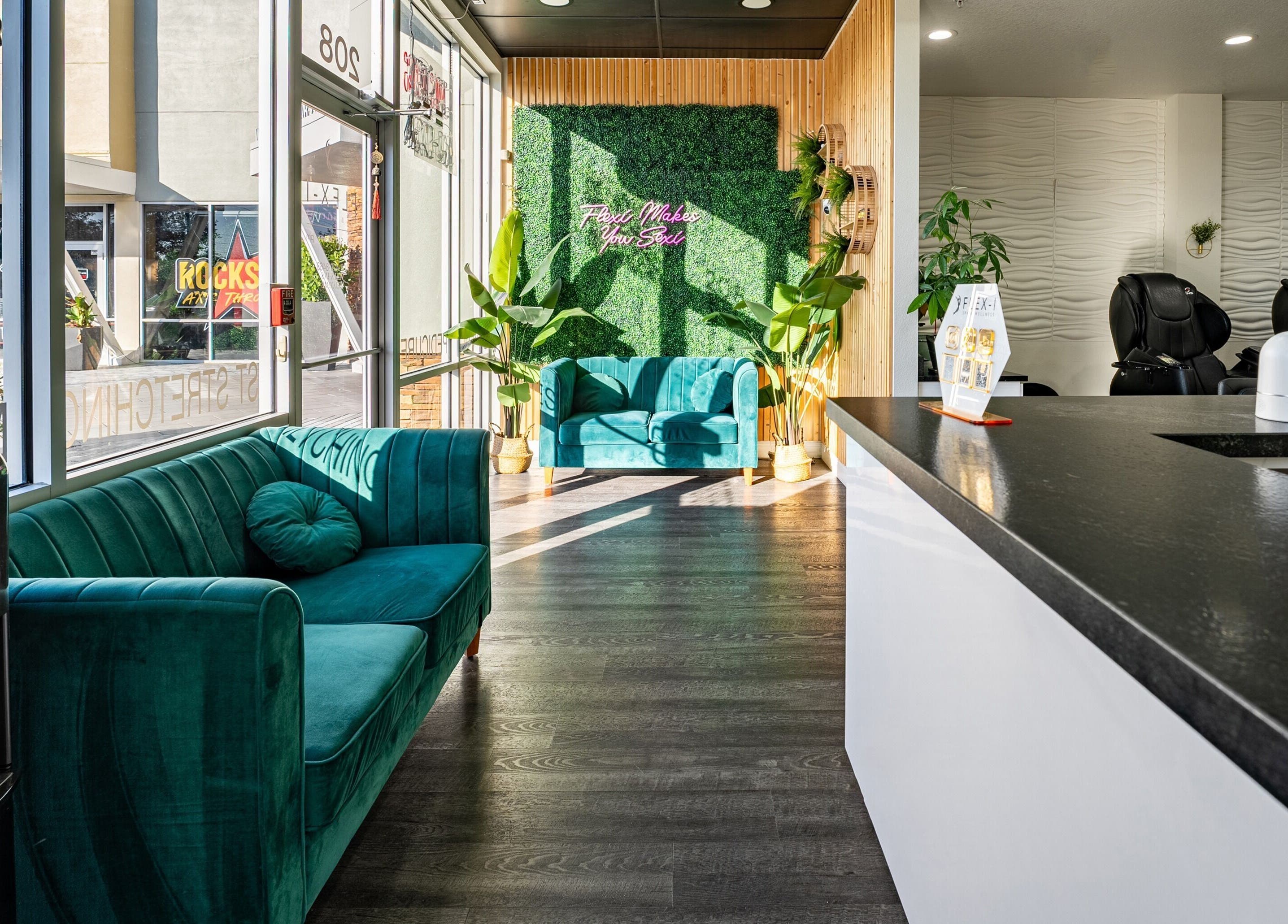 Inviting interior of Flex-I Nails Spa in Orlando, Florida, US, featuring modern teal seating and lush greenery.