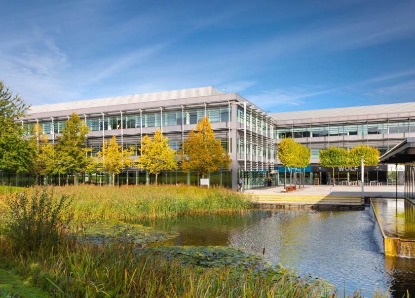 Modern facade of SHAPINS Clinic | Reading with serene pond, located in Reading, England, GB.