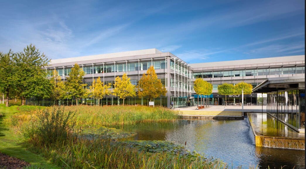 Modern facade of SHAPINS Clinic | Reading with serene pond, located in Reading, England, GB.