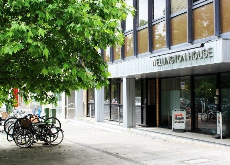 Entrance to SHAPINS Clinic at Wellington House, Cambridge, England, GB, surrounded by lush greenery.
