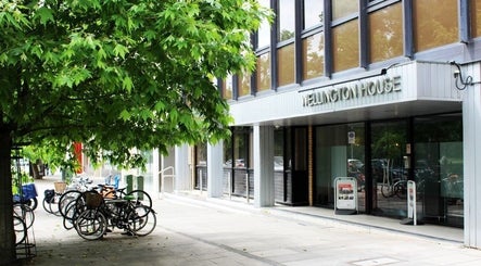 Entrance to SHAPINS Clinic at Wellington House, Cambridge, England, GB, surrounded by lush greenery.