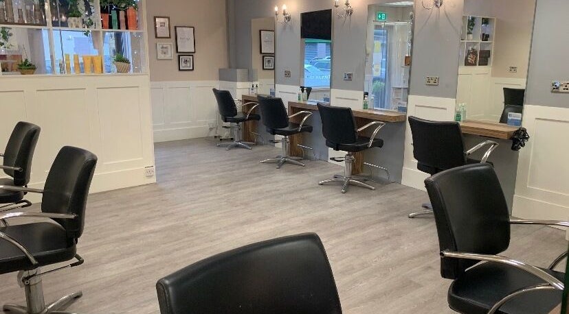 Modern interior of Judy McFaite Hairdressing in Renfrew, Glasgow, Scotland, showing stylish chairs and mirrors.