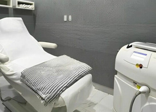 Spa treatment room at Adore Medispa, Cancún, Quintana Roo, MX, featuring a plush treatment bed and equipment.