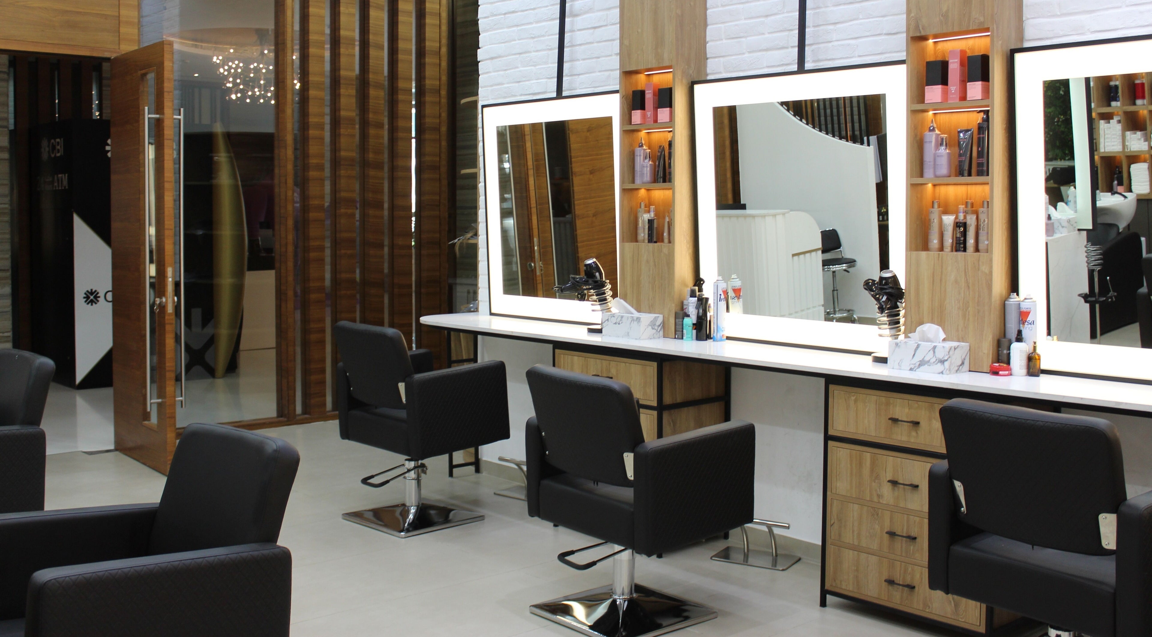 Chic salon interior at Solo Tre, Dubai, Dubai, AE with modern styling stations and plush chairs.