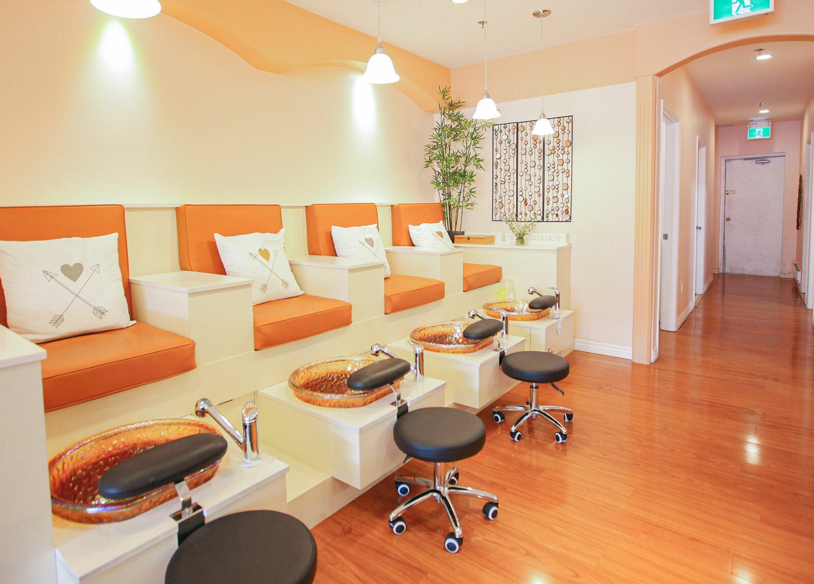 Modern pedicure area at Pinky Nails and Spa on Davisville, Toronto, Ontario, CA with orange seating.