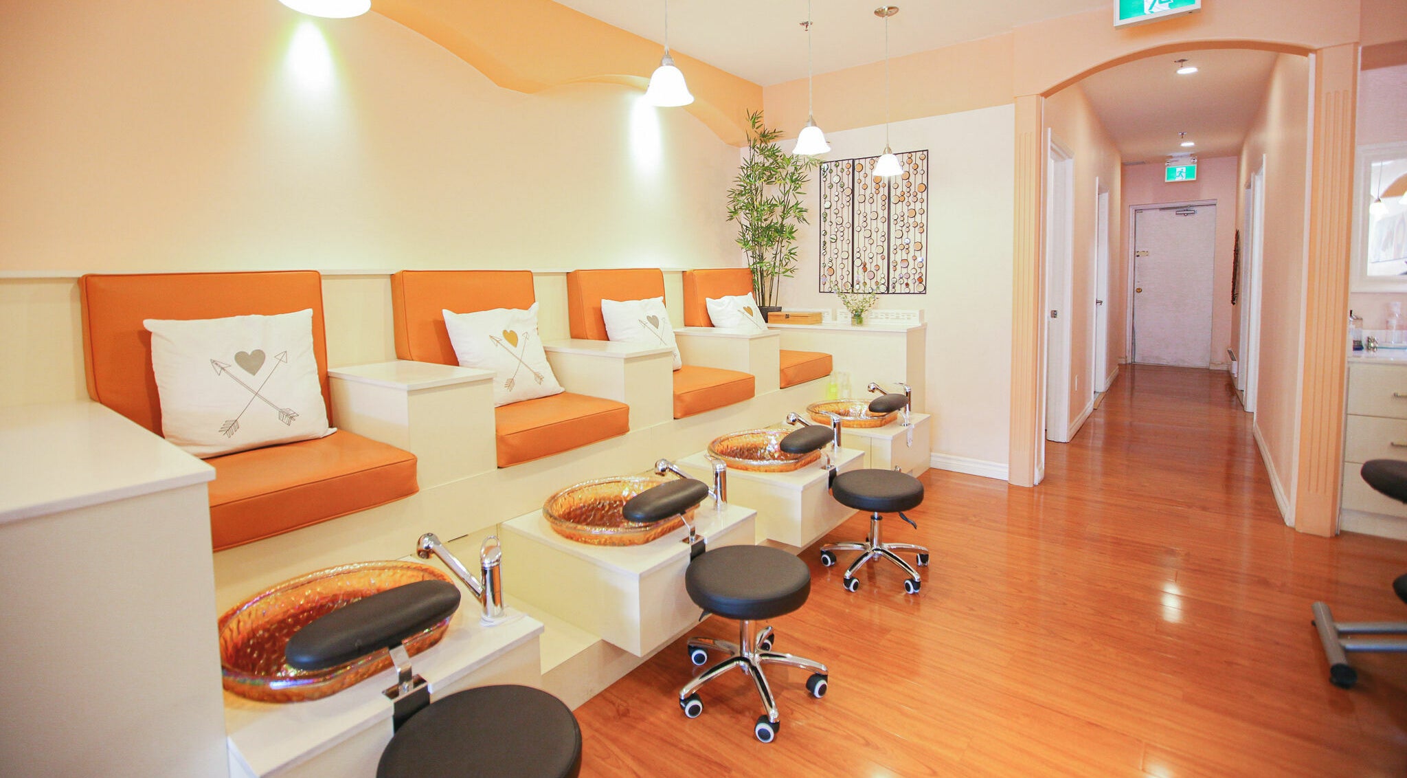 Modern pedicure area at Pinky Nails and Spa on Davisville, Toronto, Ontario, CA with orange seating.