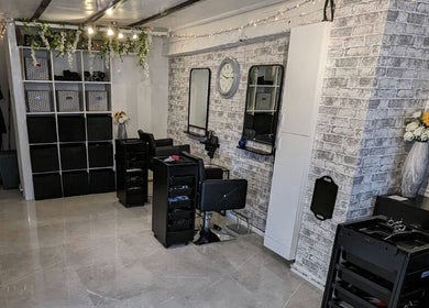Chic salon interior at Joanne Louise Hair And Beauty, Acle, England, GB showcasing elegant styling stations.