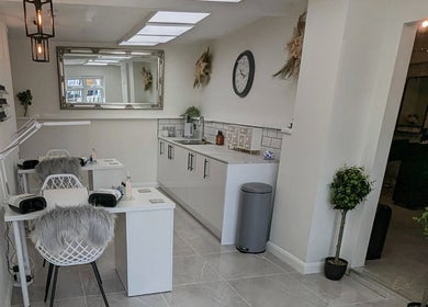 Elegant salon setup at Joanne Louise Hair And Beauty in Acle, England, GB featuring modern decor and styling stations.