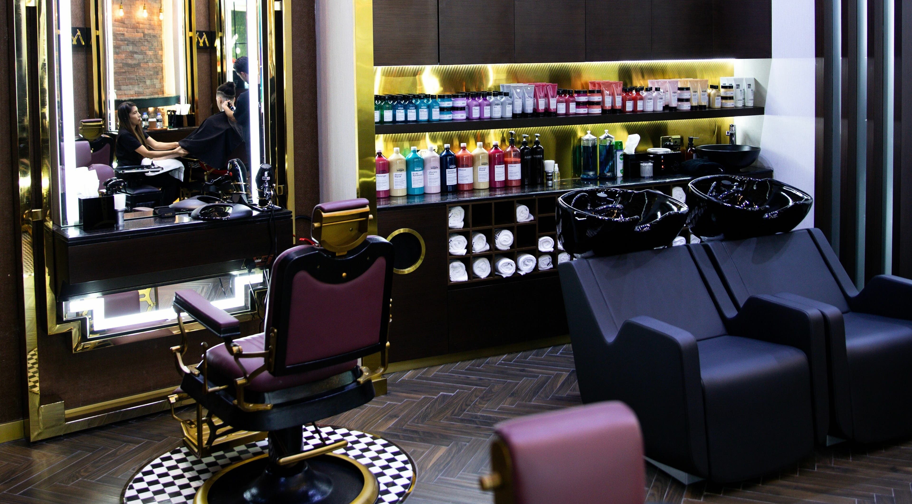 Sleek barber chairs and product shelves at Amber Gents Salon - Paramount, Dubai, AE.