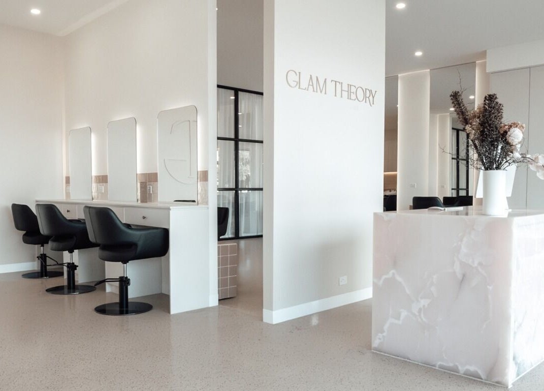 Sleek interior of Glam Theory Studios in Heathmont, Victoria, AU with modern styling chairs and marble reception.