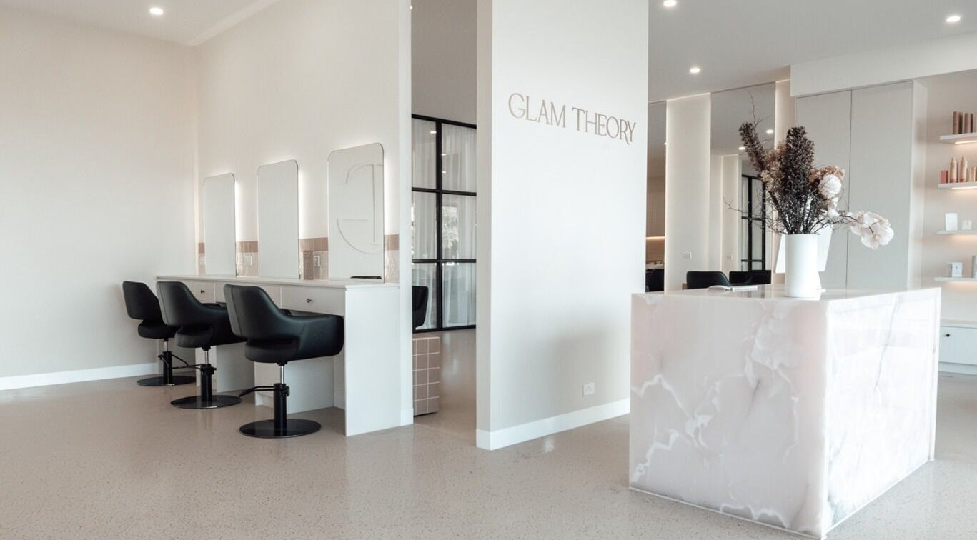 Sleek interior of Glam Theory Studios in Heathmont, Victoria, AU with modern styling chairs and marble reception.