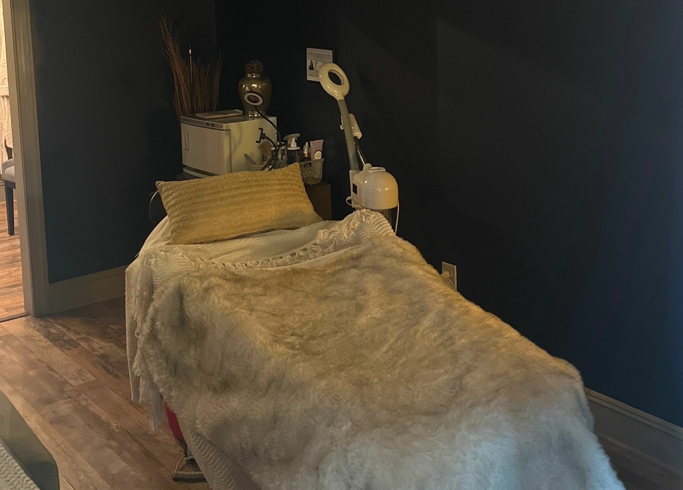 A cozy spa treatment room at Robert Joseph's Salon in Syracuse, New York, US, featuring a plush treatment bed.