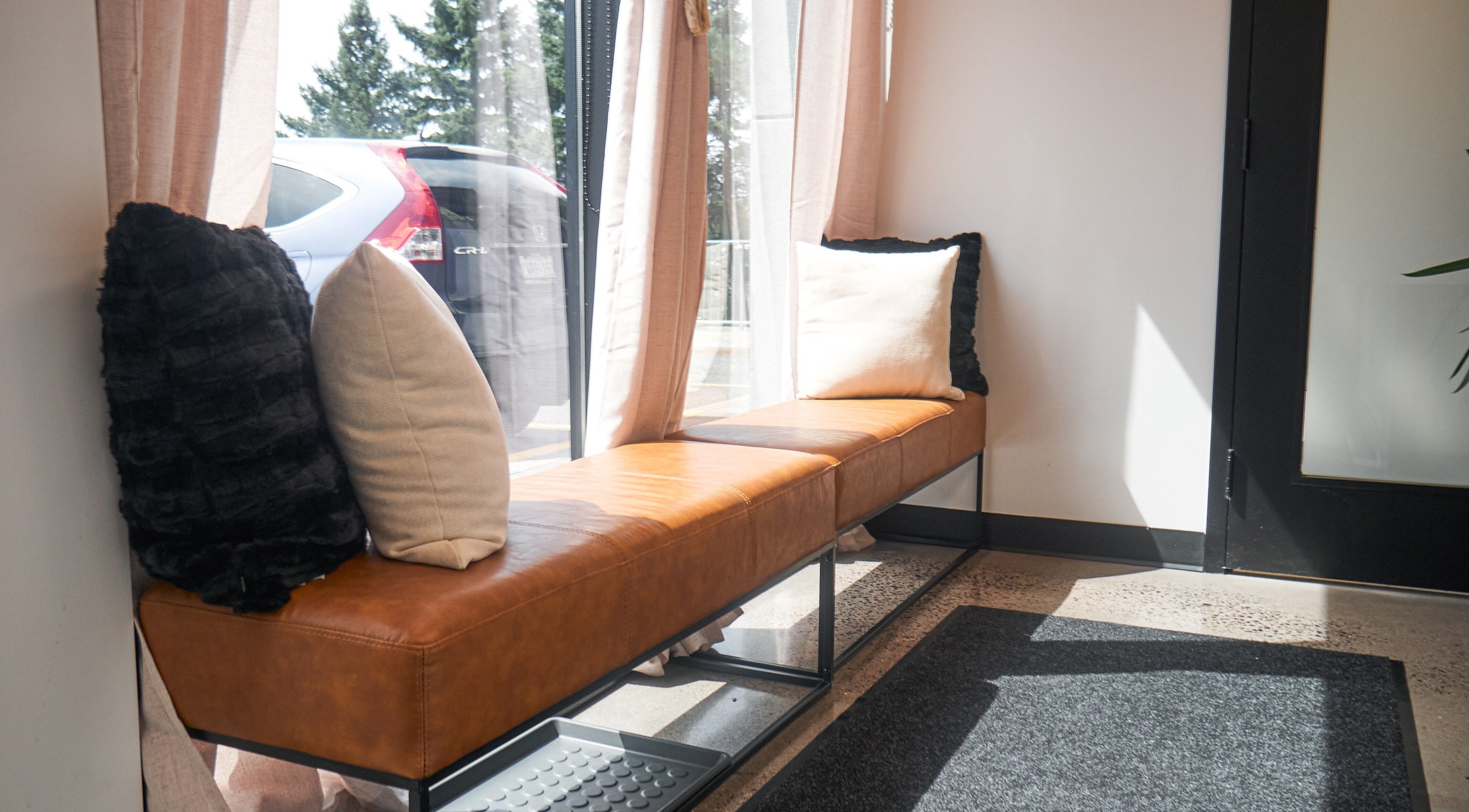 Relaxing seating at Nova Wax Bar Ltd., Ottawa, Ontario, CA with plush cushions and natural light.