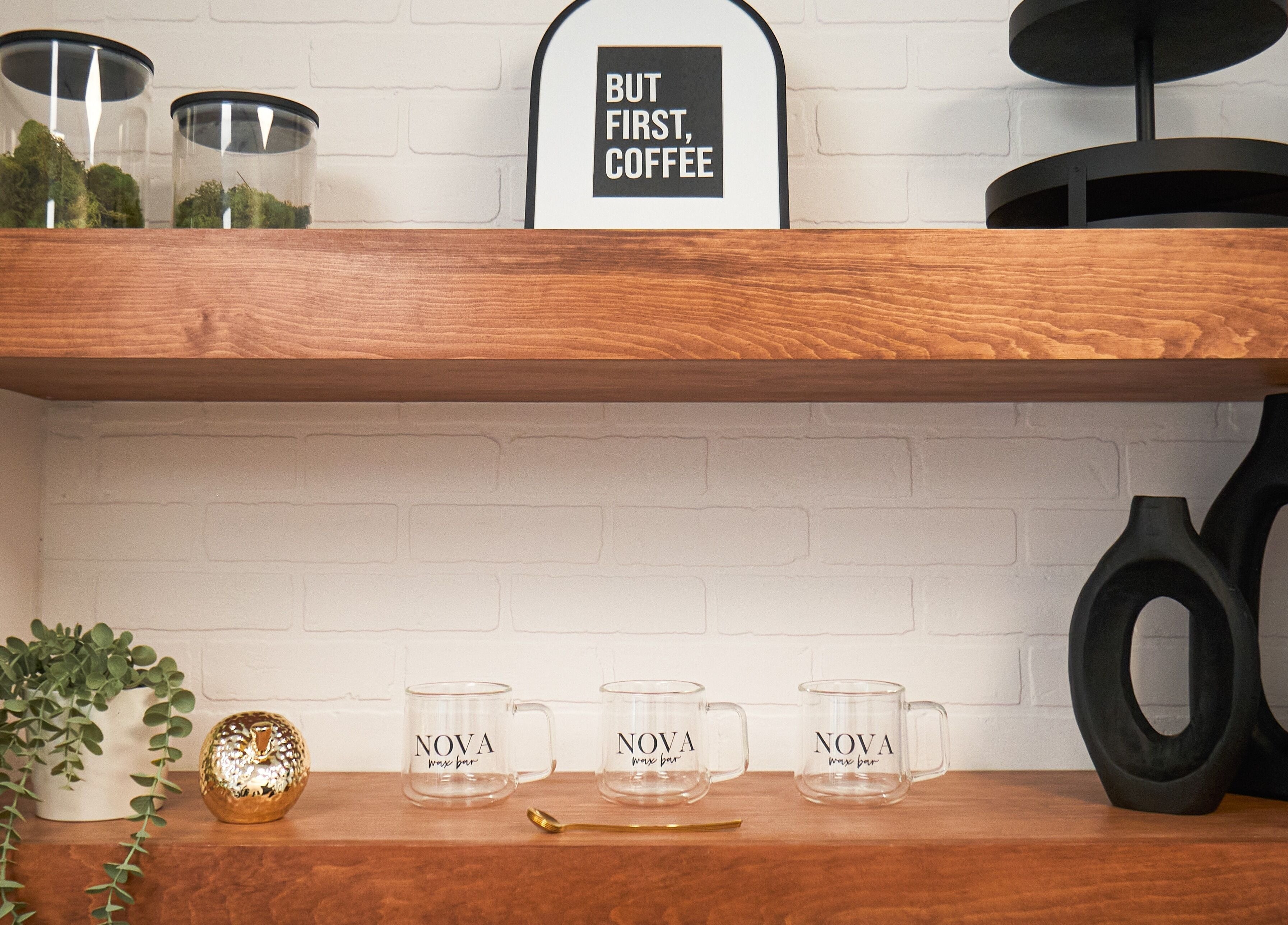 Elegant shelves at Nova Wax Bar Ltd., Ottawa, Ontario, CA, featuring decor and branded mugs.