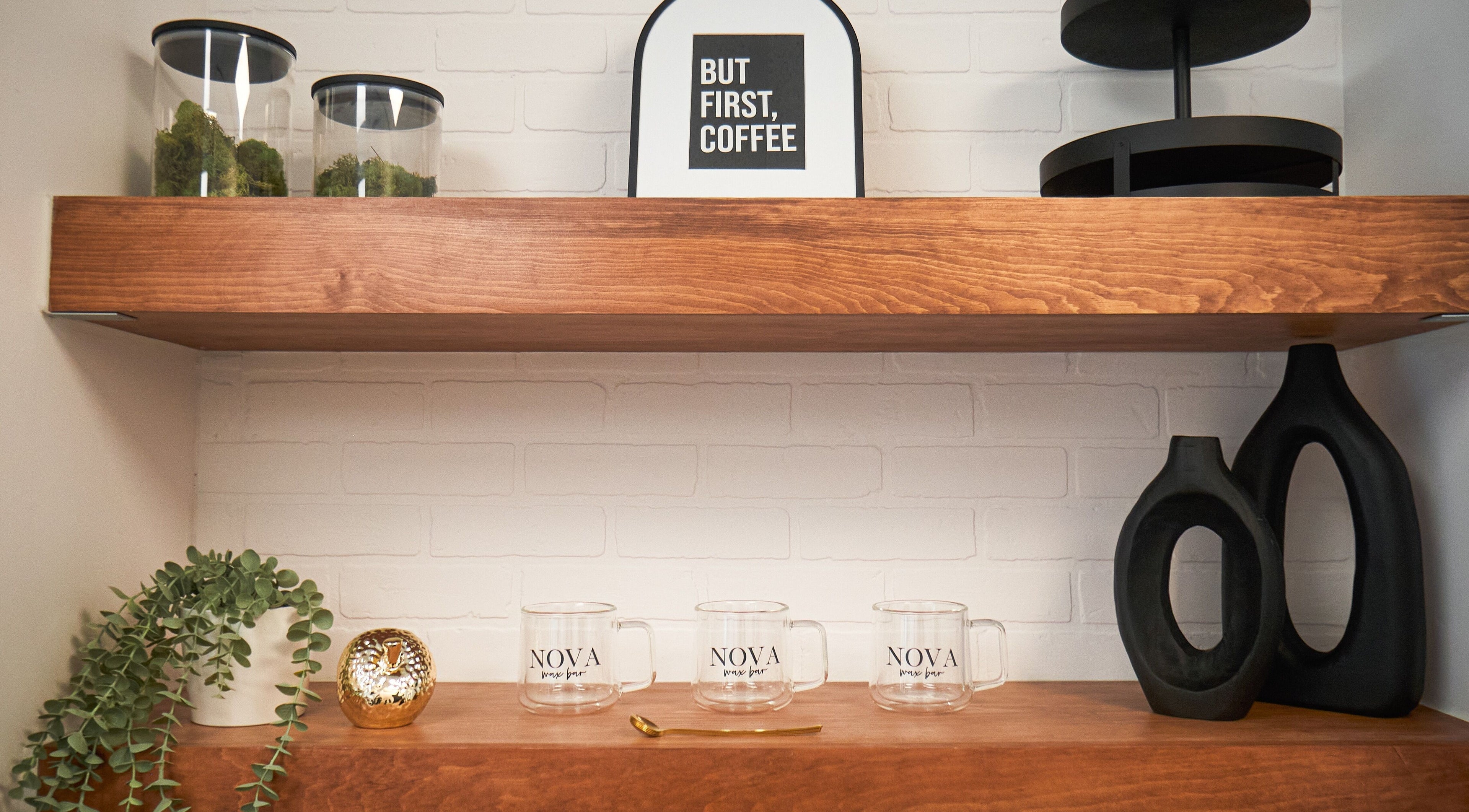 Elegant shelves at Nova Wax Bar Ltd., Ottawa, Ontario, CA, featuring decor and branded mugs.