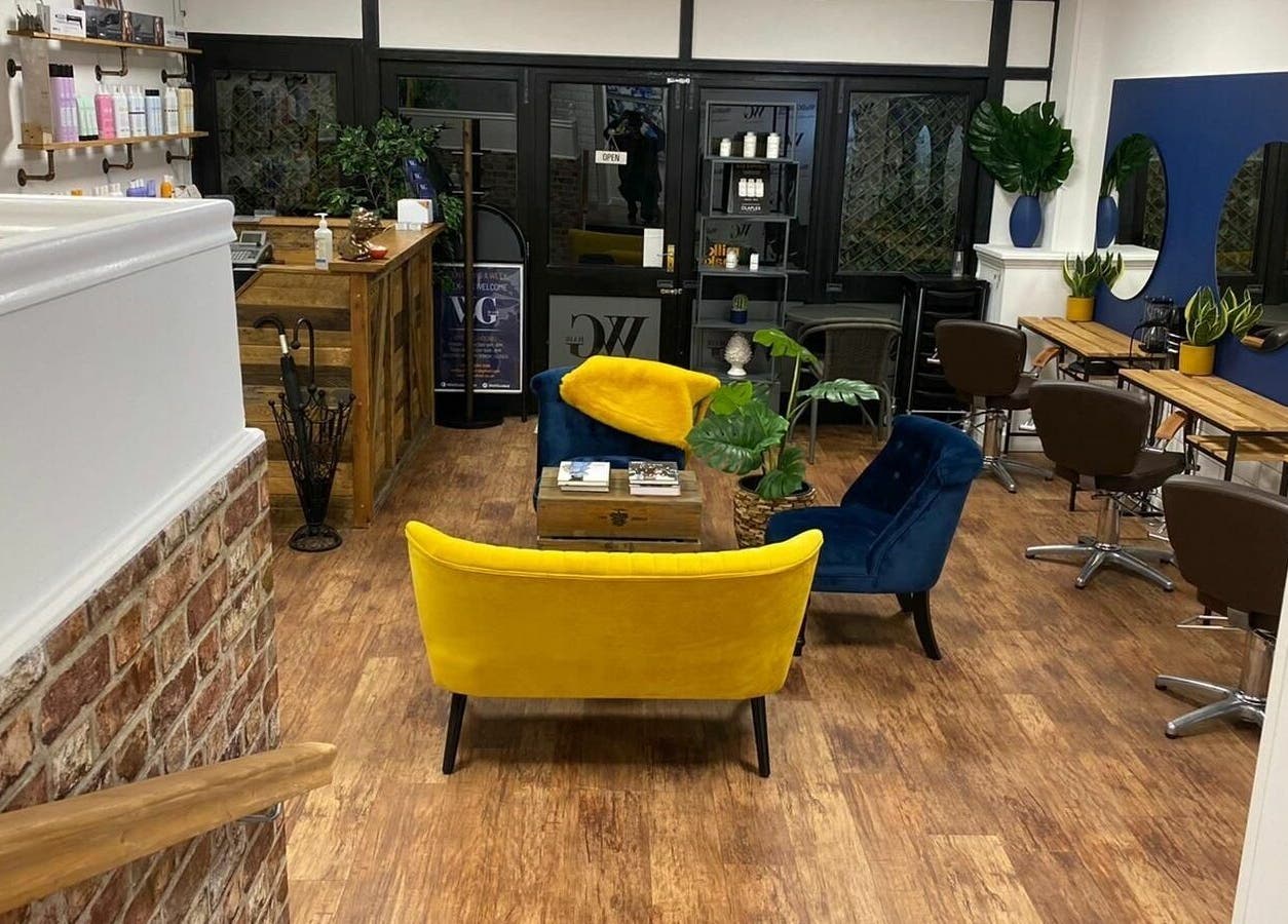 Stylish interior of Well Guided Hair, Torquay, England, GB with modern seating and mirrors.