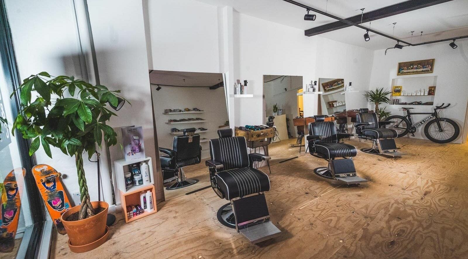 Modern barber chairs and decor at Cuts and Creps, Bristol, England, GB, showcasing a stylish interior.
