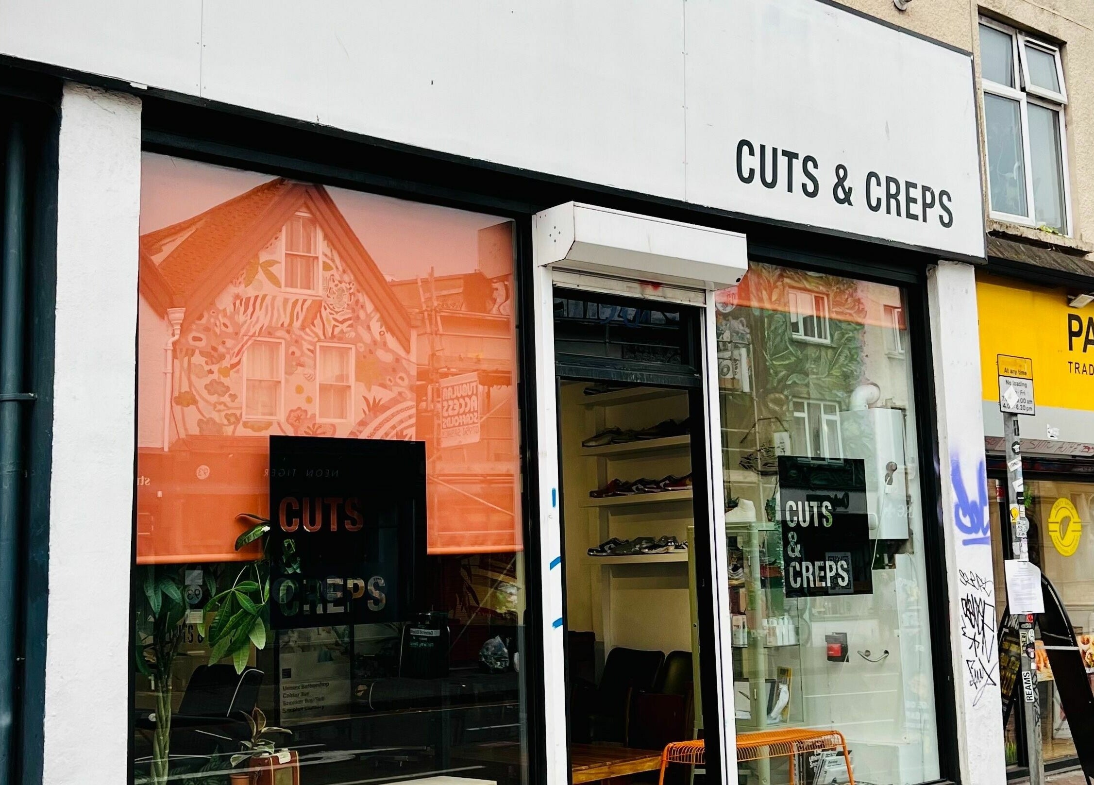 Street view of Cuts and Creps in Bristol, England, GB, highlighting its modern storefront.