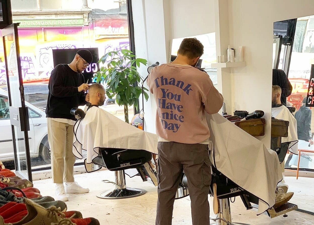 Barbers crafting styles at Cuts and Creps, a vibrant beauty venue in Bristol, England, GB.