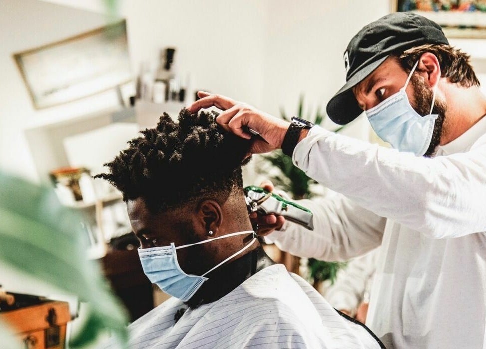 Stylist at Cuts and Creps in Bristol, England, GB, performing a haircut with attention to detail.