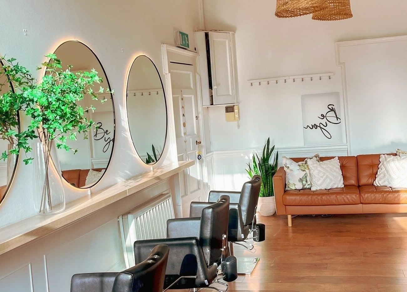 Stylish interior of Gabriela Leite Curly Hair Salon in Dublin, County Dublin, IE with mirrors and comfy seating.
