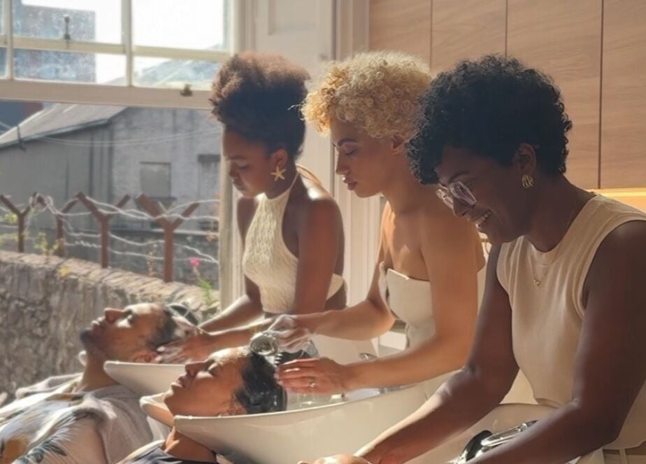 Stylists washing hair at Gabriela Leite Curly Hair Salon, Dublin, County Dublin, IE under natural light.
