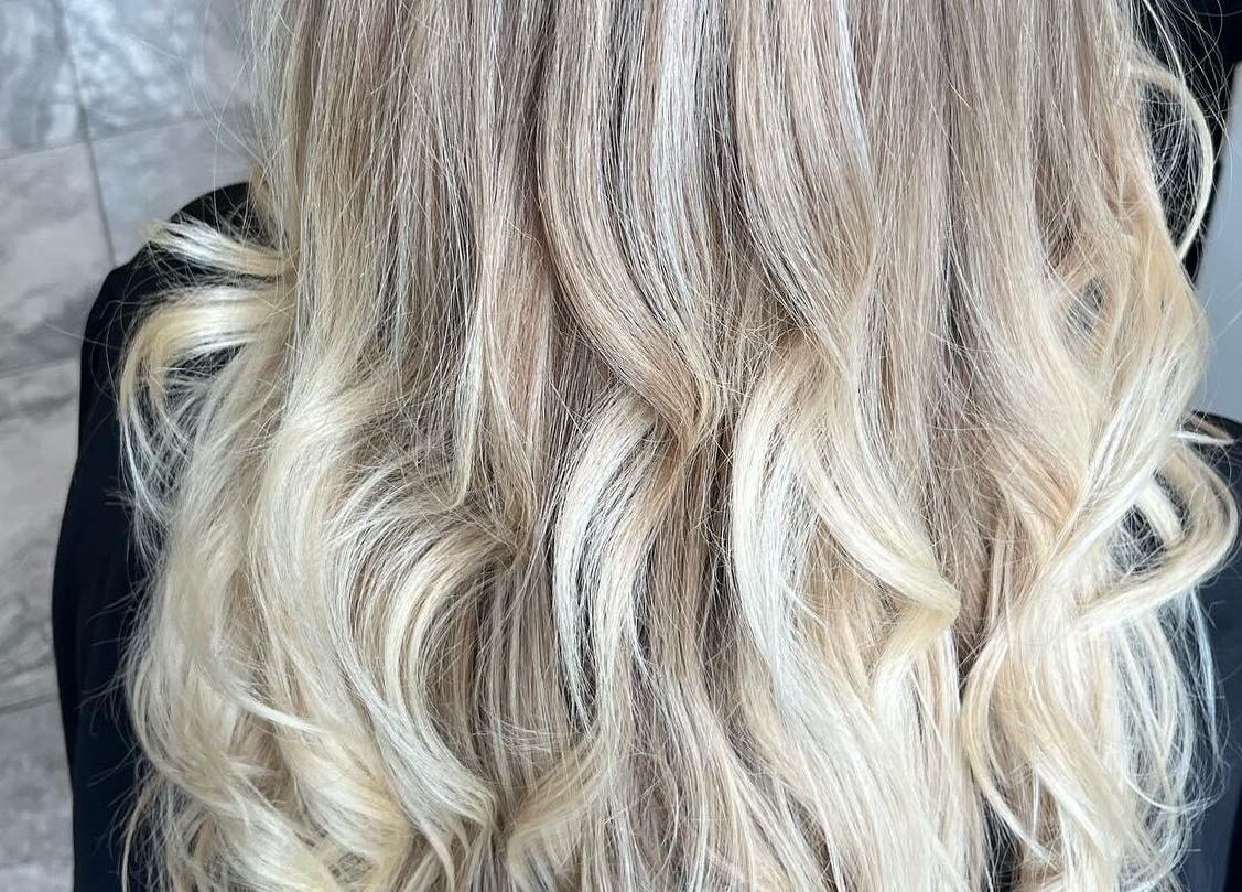 Blonde wavy hairstyle at Salon Seven, Wivenhoe, England, GB showcasing vibrant curls.