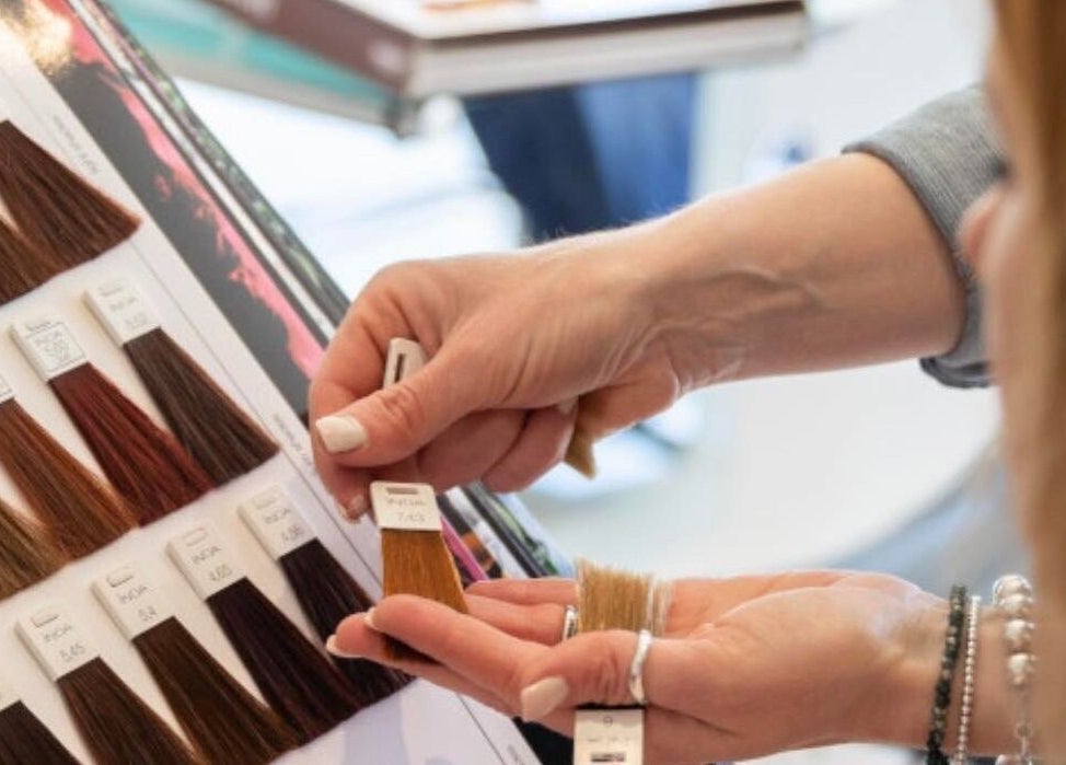 Client choosing hair colors at Salon Seven in Wivenhoe, England, GB from a color swatch book.