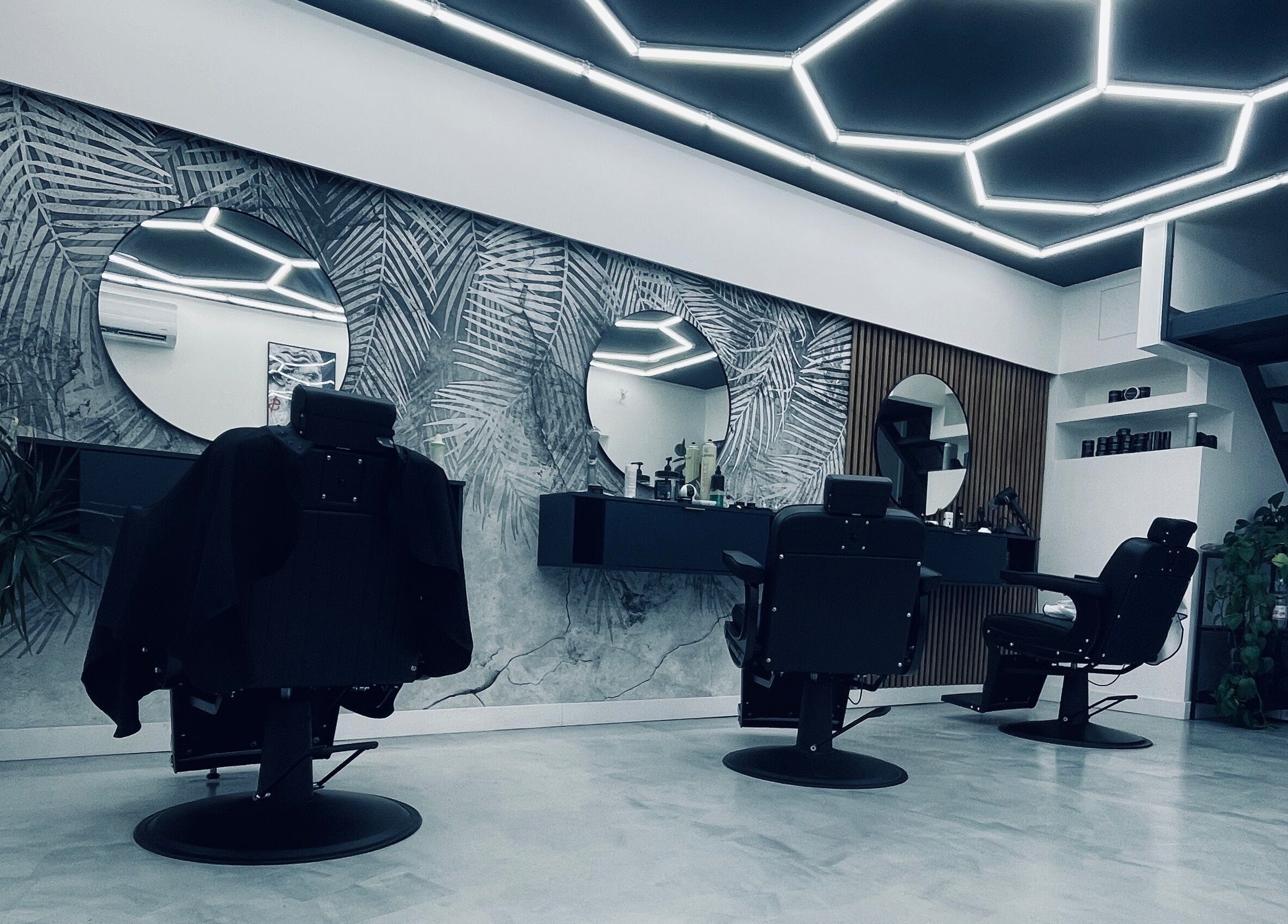 Stílusos borbélyszékek és tükör a Perspective Men's Grooming szalonban, Budapest, Magyar, HU.