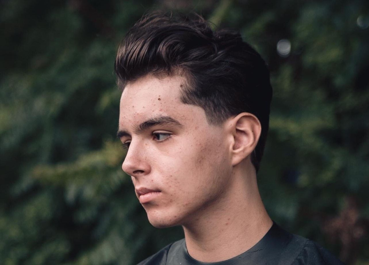 Fiatal férfi modern hajvágással a Perspective Men’s Grooming előtt, Budapest, Magyar, HU.