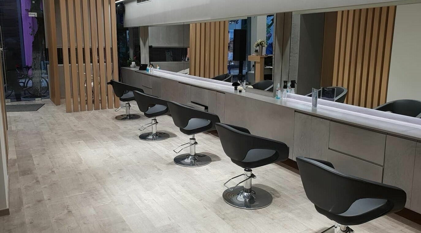 Εσωτερικό κομμωτηρίου Nice Hair στη Χανιά, Ελλάδα, GR με μοντέρνες καρέκλες και καθρέφτες.