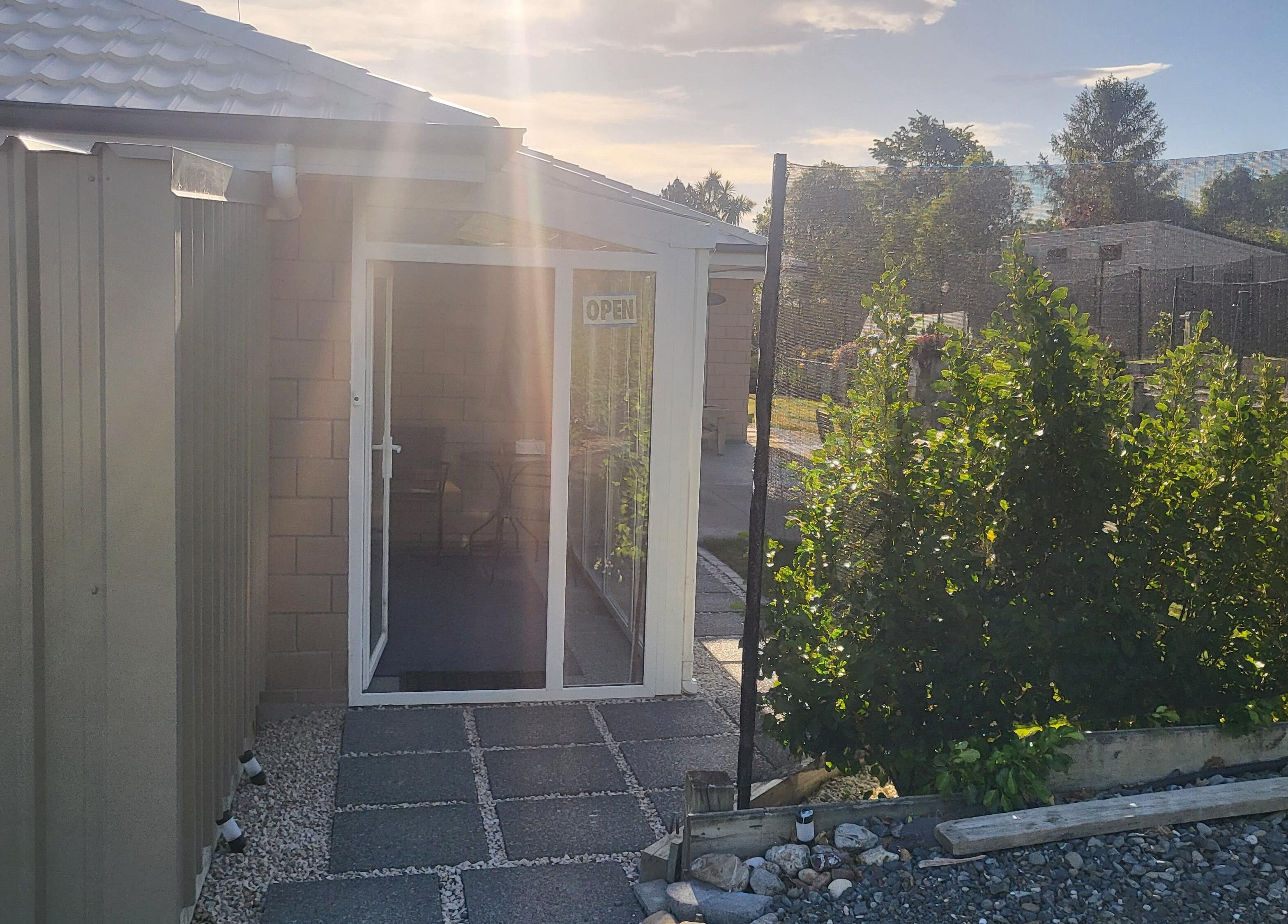 Exterior view of Dr Derek Patton's wellness center at Amberley, North Canterbury, NZ with sunlit entrance.