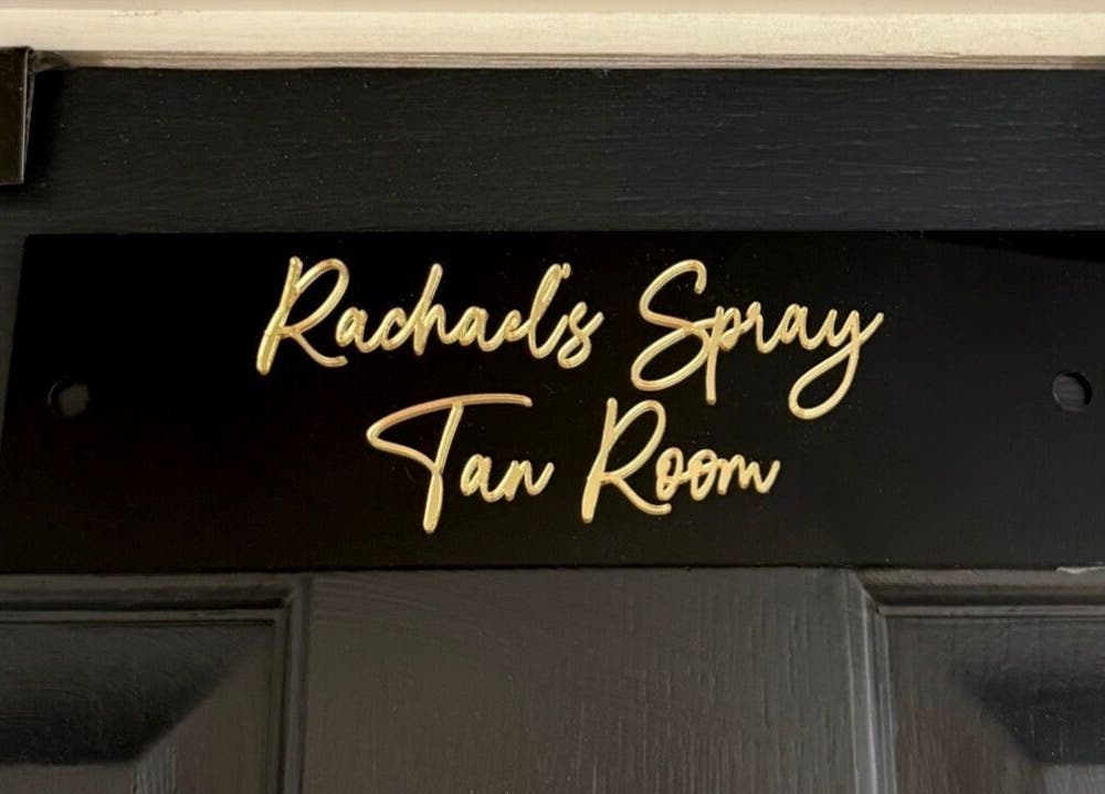 Gloss & Glo's spray tan room sign in Paisley, Scotland, GB, featuring elegant script on a door plaque.