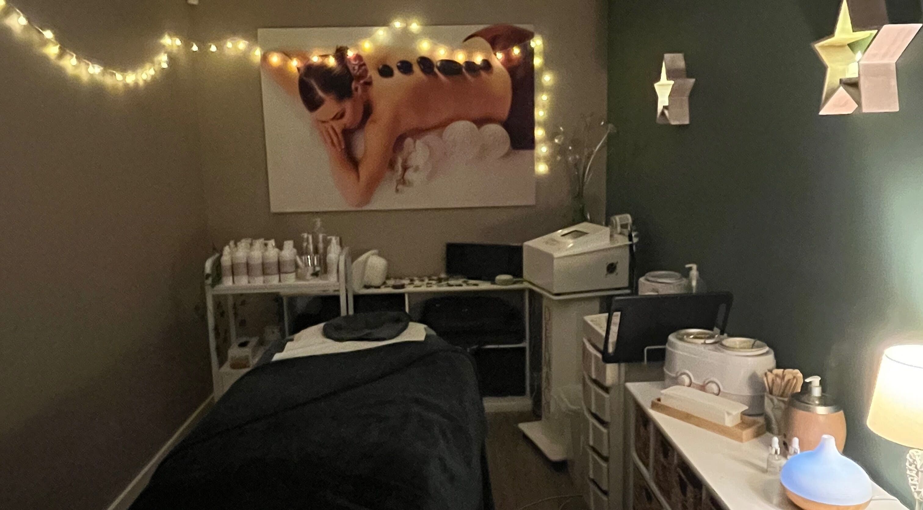 Relaxing treatment room at Midsomer Beauty Salon Ltd, Chilcompton, England, GB with atmospheric lighting and decor.