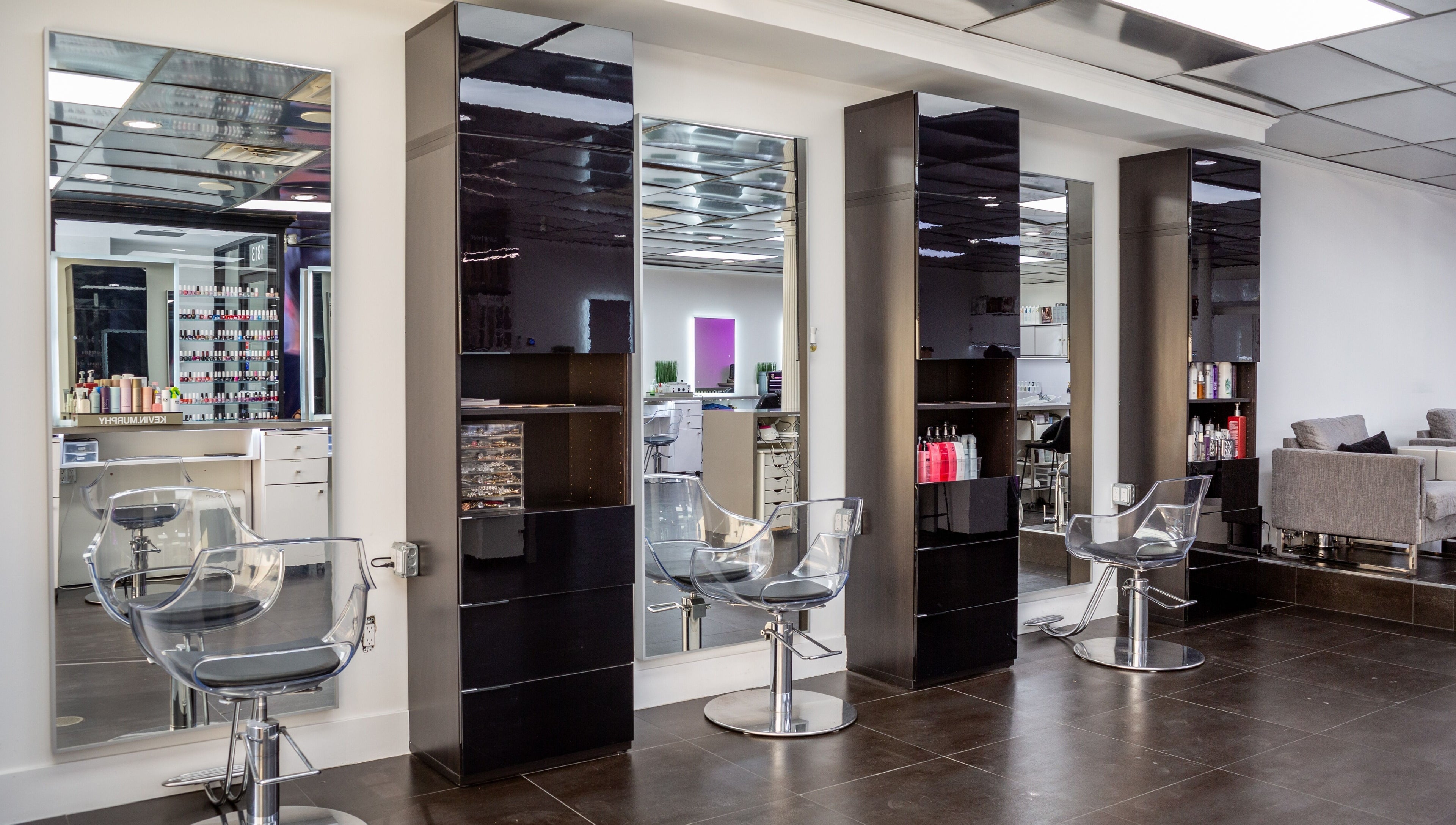 Modern hair styling stations at Salon Creer & Spa in Glendale, California, US, featuring sleek mirrors and chairs.