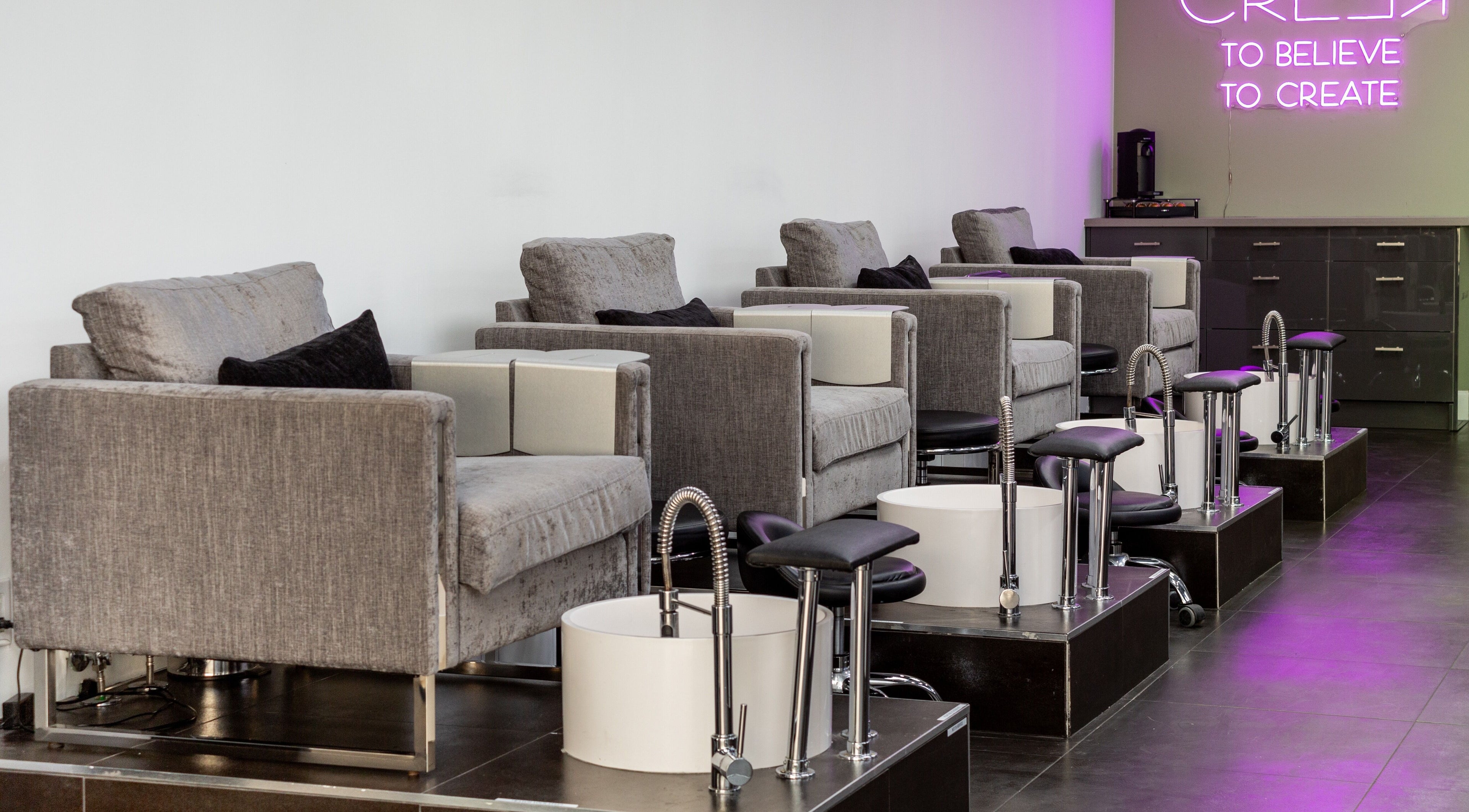 Elegant pedicure chairs at Salon Creer & Spa, Glendale, California, US, under soft neon lighting.