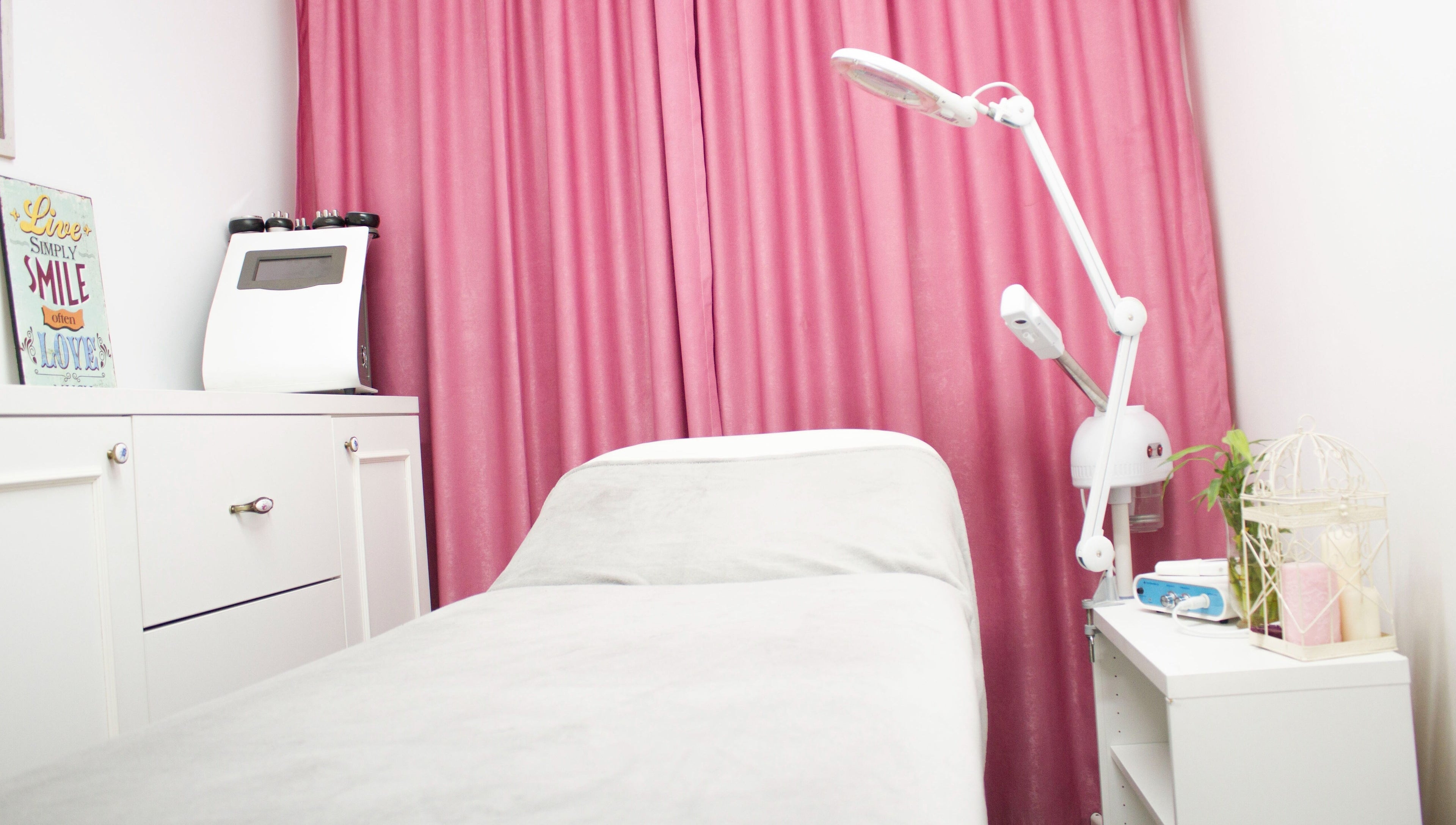 Sala de tratament elegantă la Sugar Beauty Studio, București, București, RO, cu decor roz și alb.