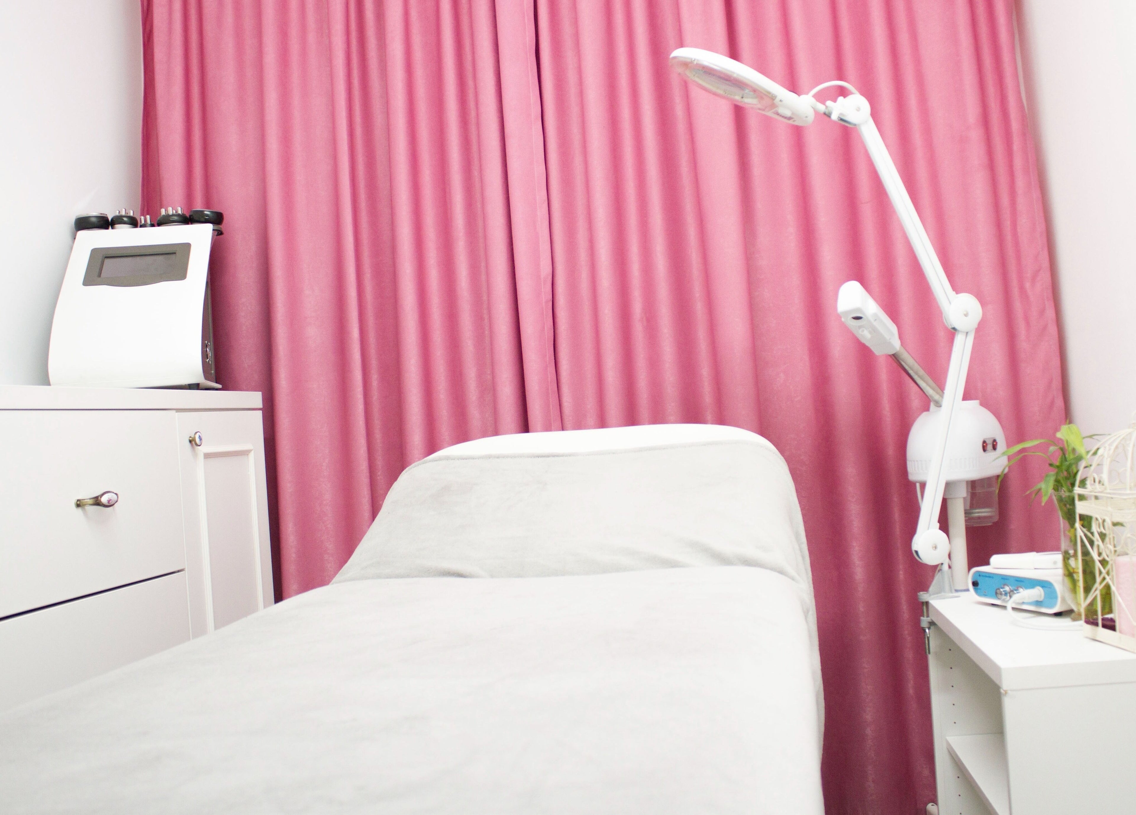 Sala de tratament elegantă la Sugar Beauty Studio, București, București, RO, cu decor roz și alb.