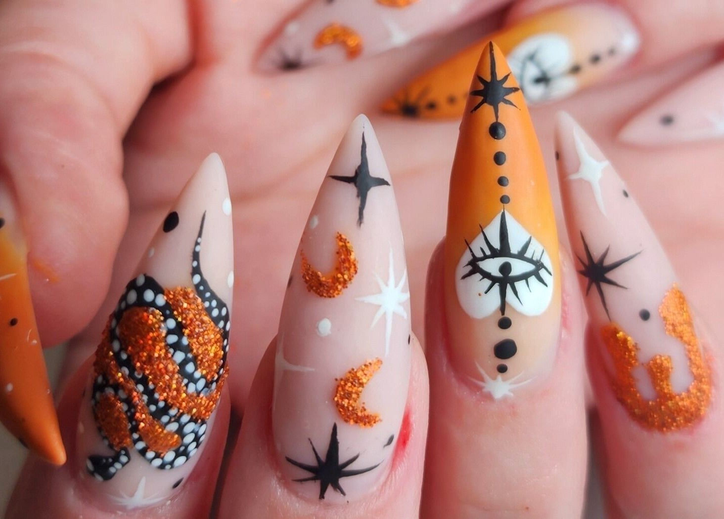 Creative nail art at Sondra's Nails and Esthetics in Lethbridge, Alberta, CA. Intricate designs with orange accents.