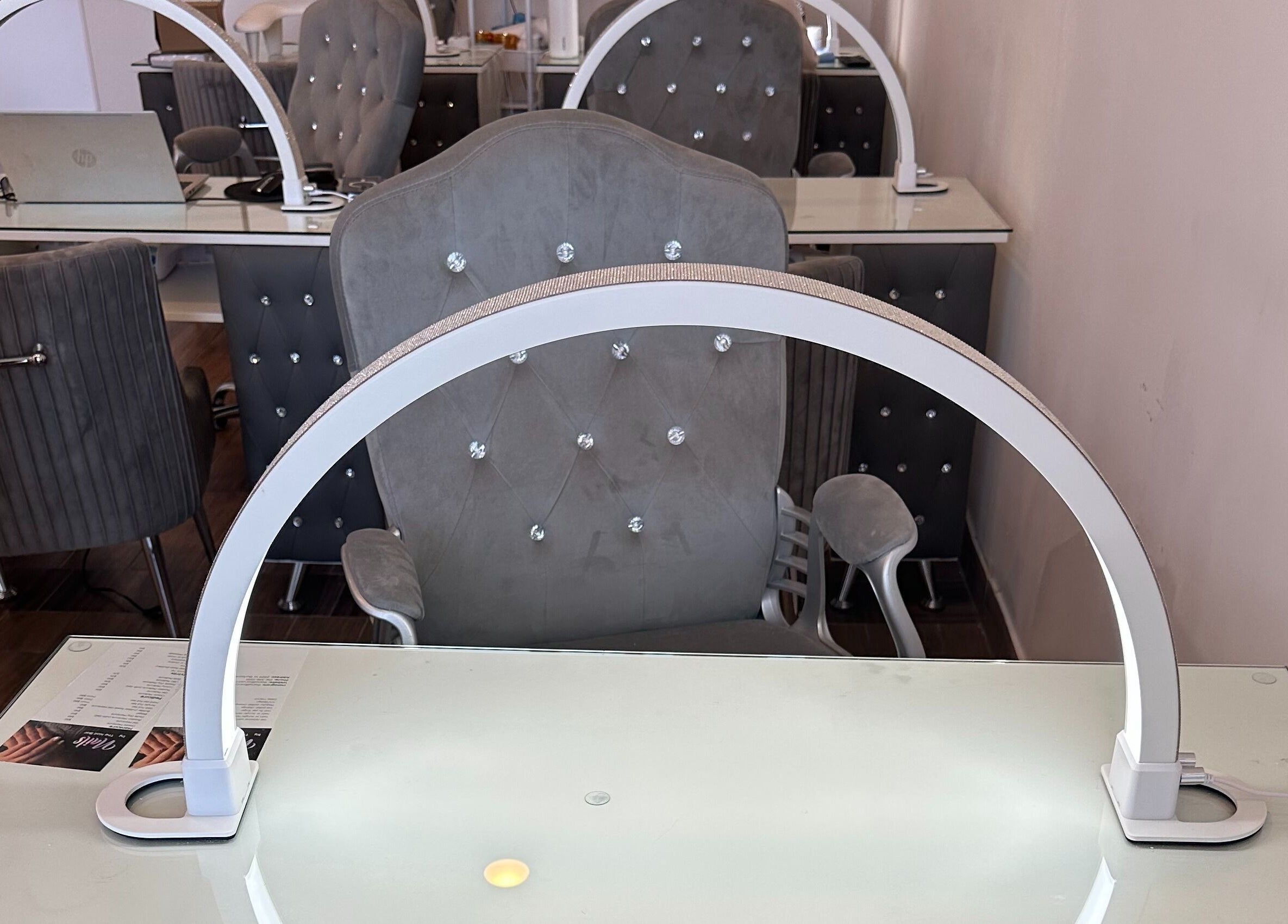 Chic nail station at The Nail Bar, Burbank, California, US, featuring plush chairs and sleek worktops.