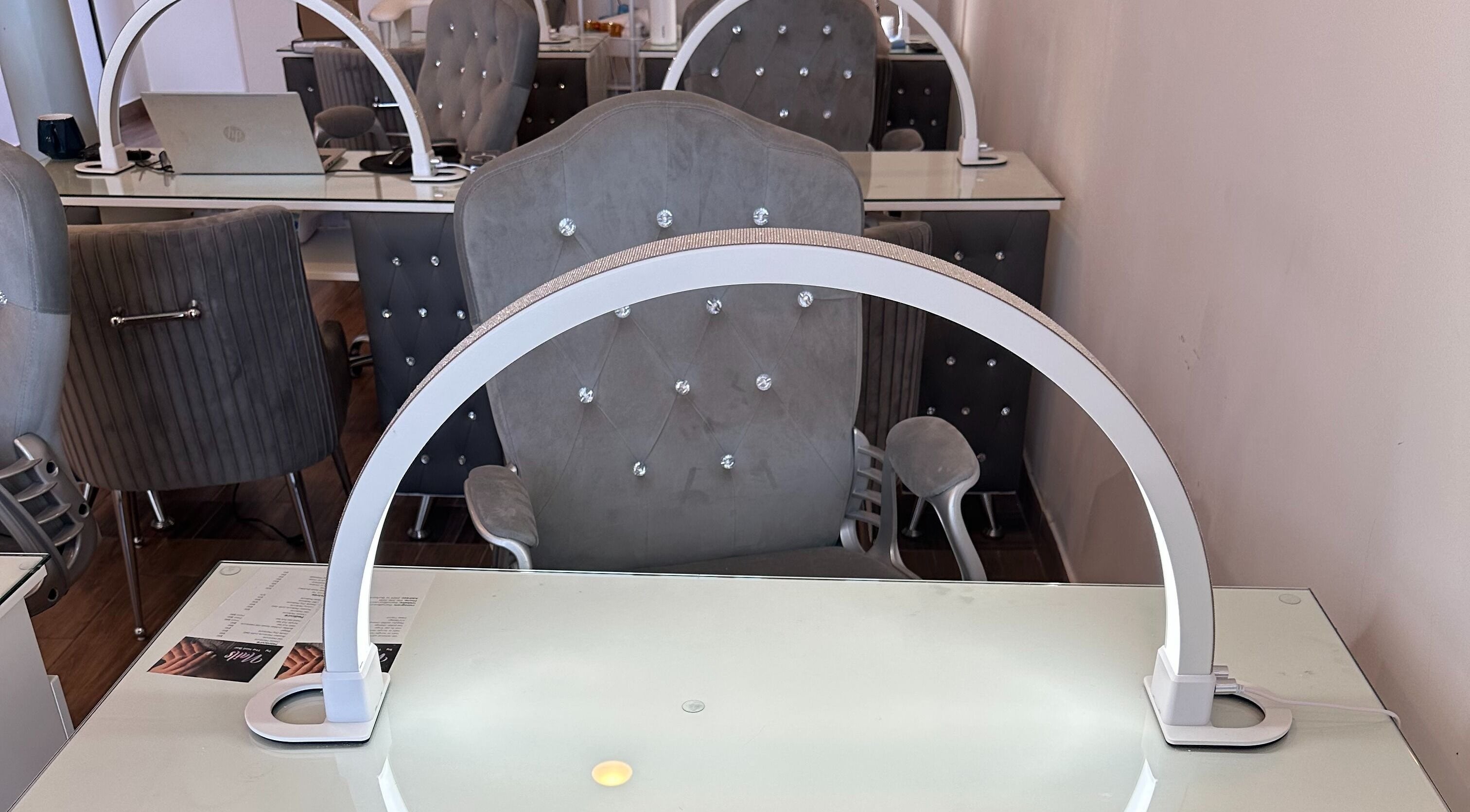 Chic nail station at The Nail Bar, Burbank, California, US, featuring plush chairs and sleek worktops.