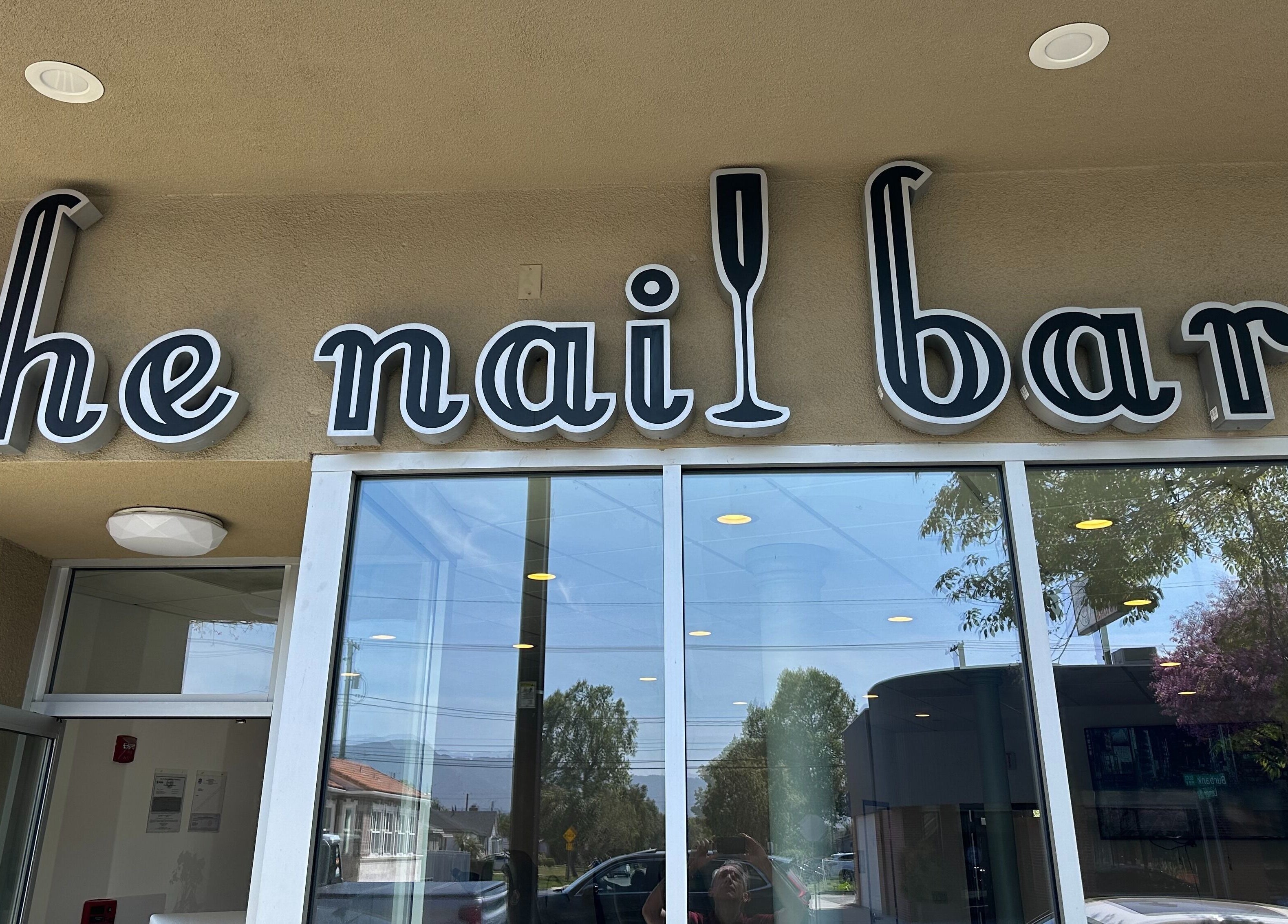 Exterior view of The Nail Bar in Burbank, California, US featuring stylish signage above glass doors.