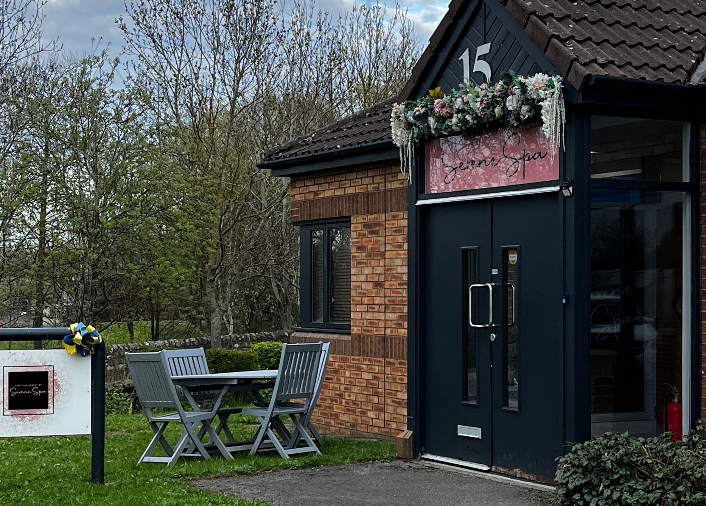 Entrance of Serene Spa in Barnard Castle, England, GB, with outdoor seating and lush greenery.