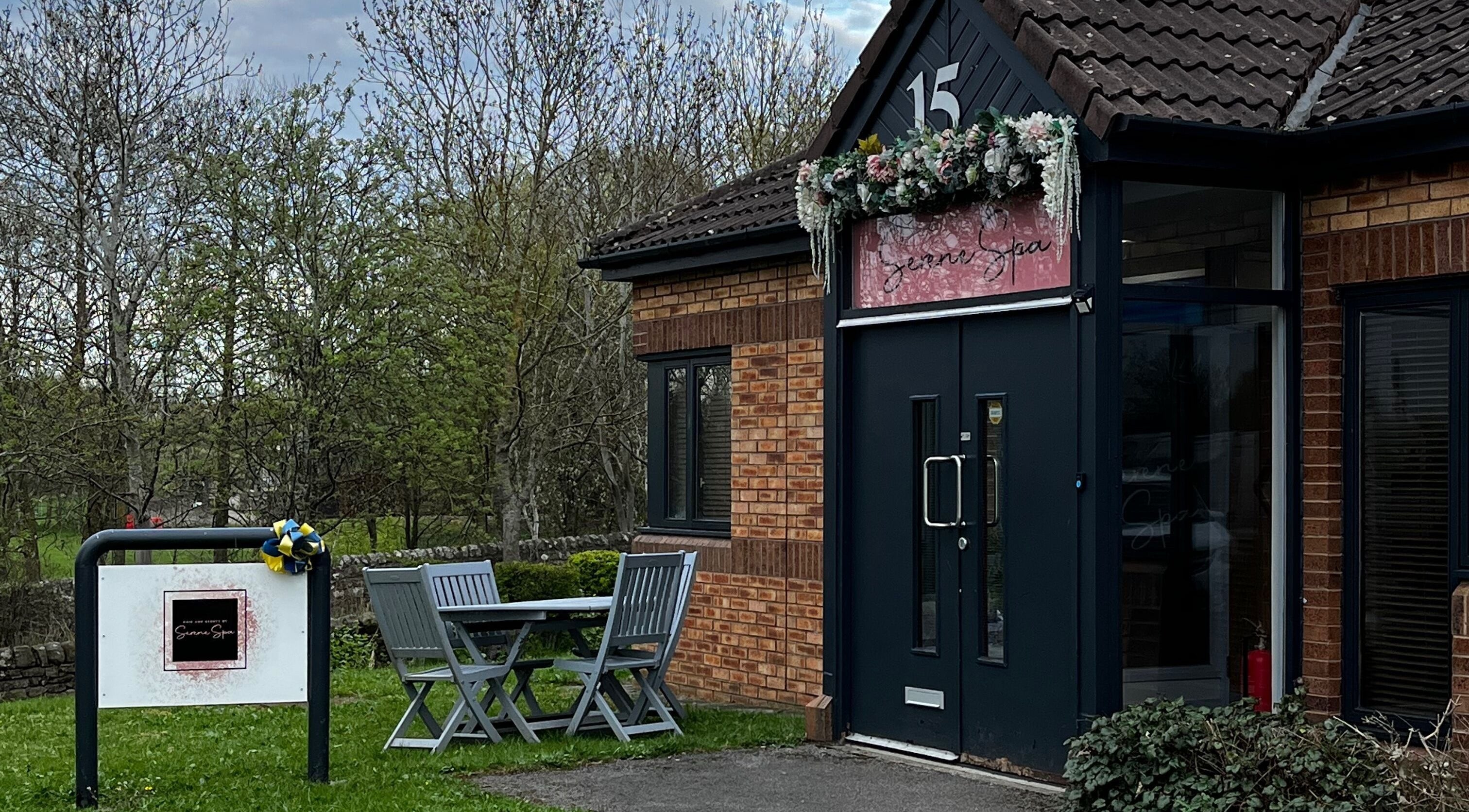 Entrance of Serene Spa in Barnard Castle, England, GB, with outdoor seating and lush greenery.