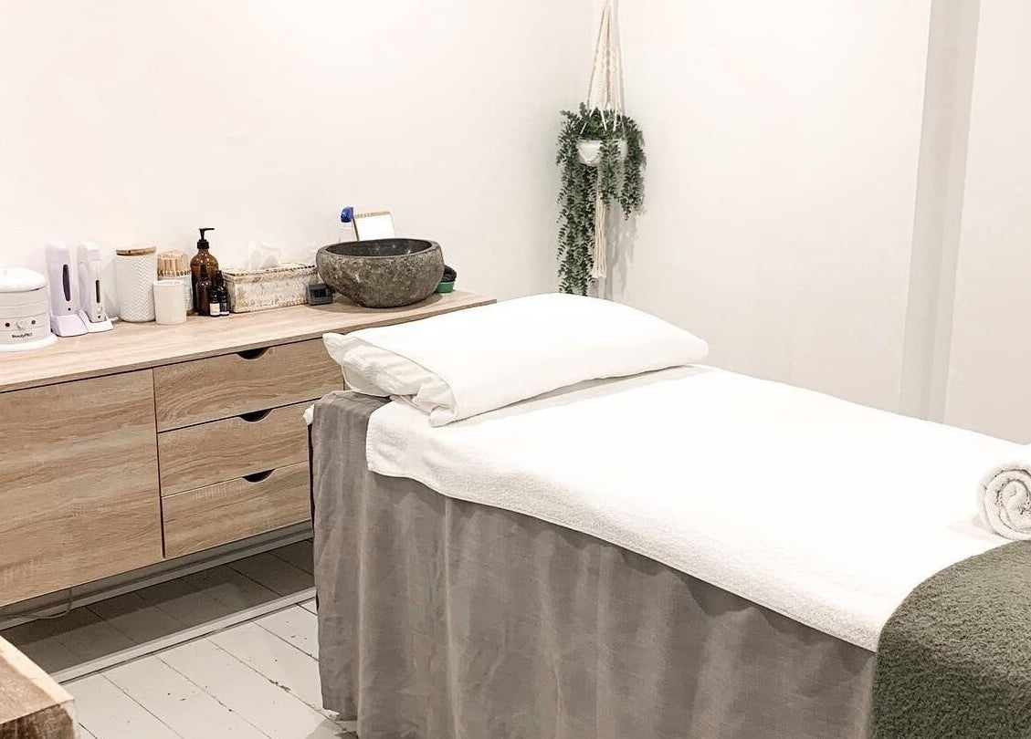 Tranquil treatment room at Oura Day Spa, Gisborne, NZ with a massage table and calming decor.