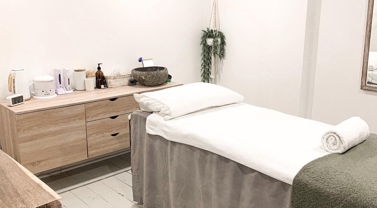 Tranquil treatment room at Oura Day Spa, Gisborne, NZ with a massage table and calming decor.