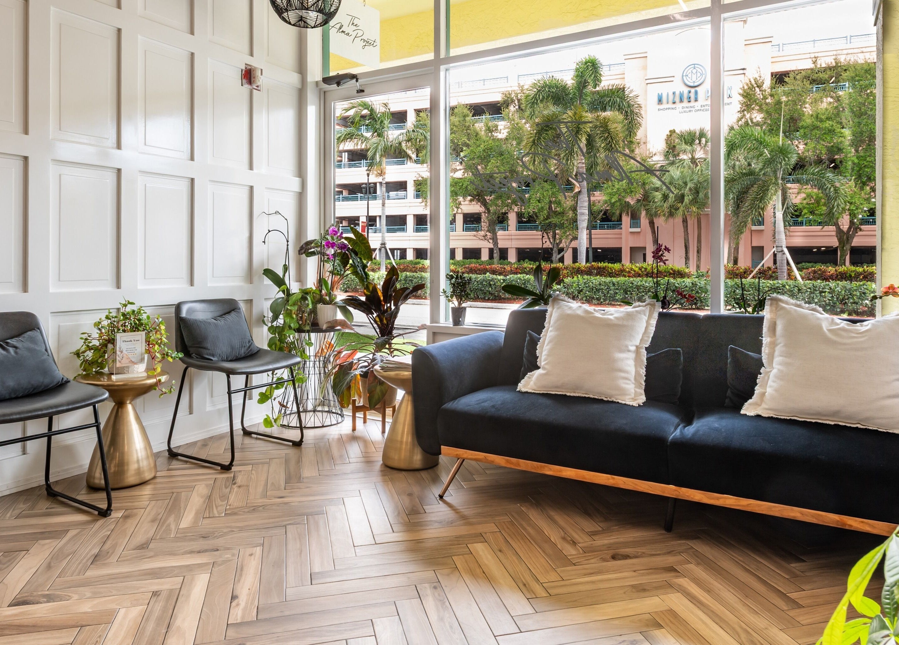 Sophisticated waiting area at The Alma Project by AG in Boca Raton, Florida, US with modern chairs and plant decor.