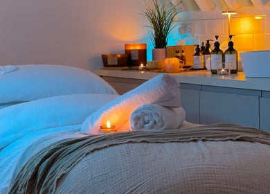 Cozy spa room at Beauty + Wellness by Faye Jervis in Sheffield, England, GB with candles and soft towels.