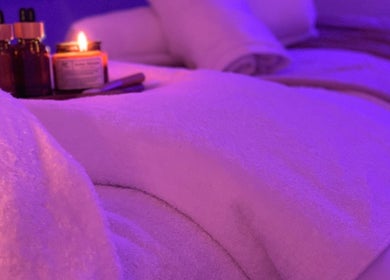 Relaxing spa setup at Beauty + Wellness by Faye Jervis, Sheffield, England, GB featuring candles and oils.
