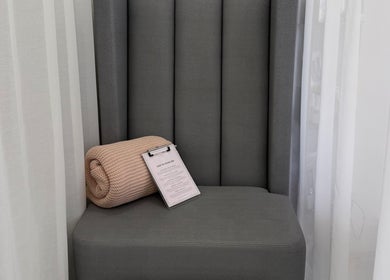 Relaxing seating area at Aurae London - Nail Artistry & Beauty, Romford, England, GB with comfy throw and clipboard.